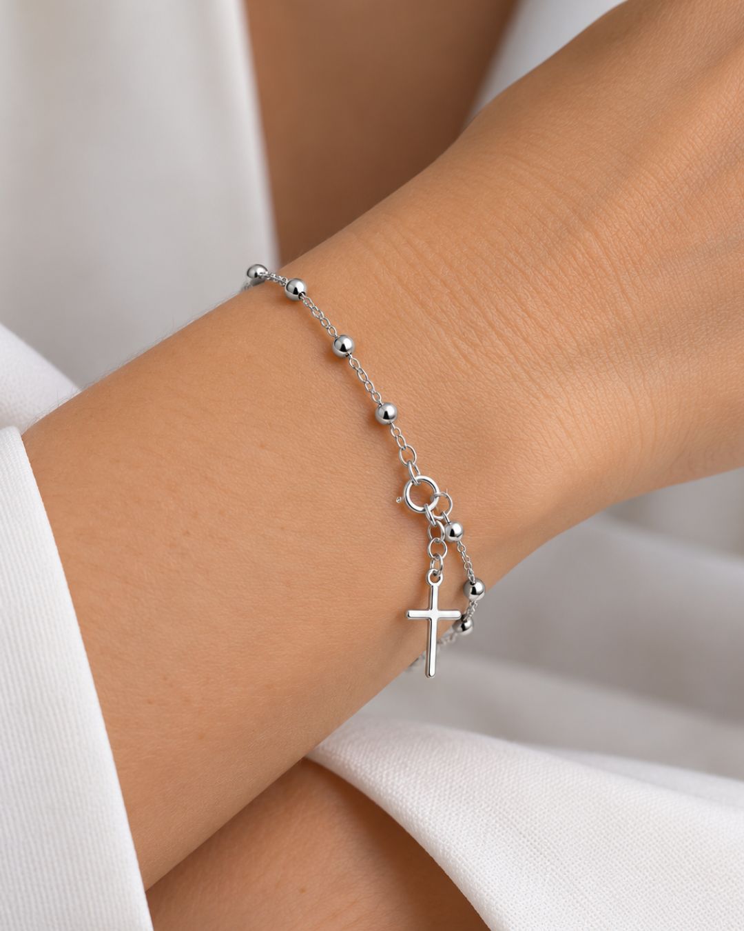 Pulsera de plata 925 denario con cuentas de 4mm y cruz y regulación en el extremo colocada en muñeca Pulsera de plata 925 denario con cuentas de 4mm y cruz y regulación en el extremo colocada en muñeca