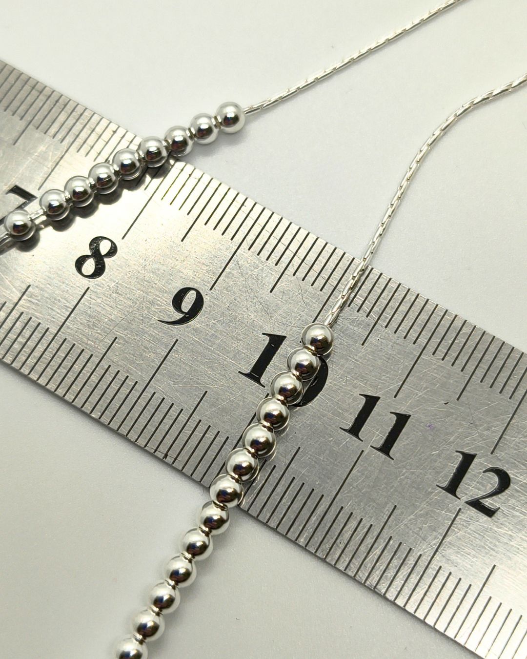 Collar de plata 925 con centro de bolitas de 3mm vista sobre regla para contexto de medida Collar de plata 925 con centro de bolitas de 3mm vista sobre regla para contexto de medida