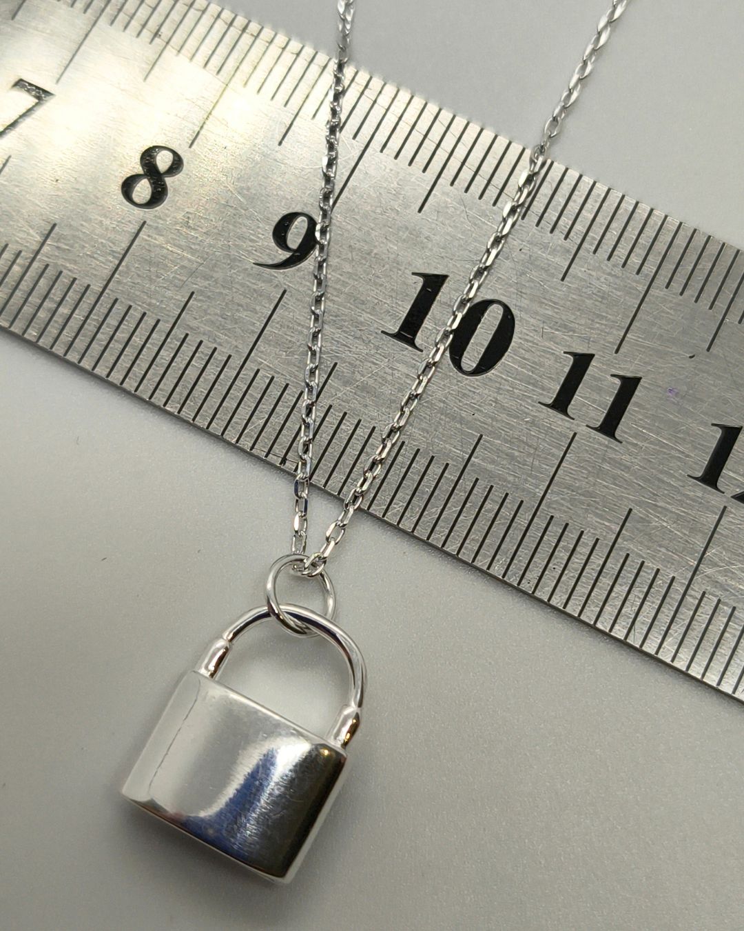 Collar de plata 925 con candado cubierto de circonias vista posterior sobre regla para contexto de medida Collar de plata 925 con candado cubierto de circonias vista posterior sobre regla para contexto de medida