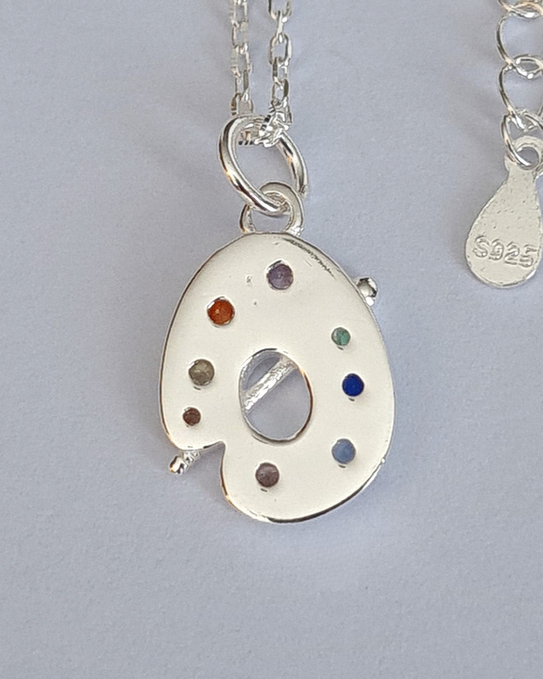 Collar de plata 925 con dije de paleta de pintor con circonias de color engarzadas y pincel vista posterior Collar de plata 925 con dije de paleta de pintor con circonias de color engarzadas y pincel vista posterior