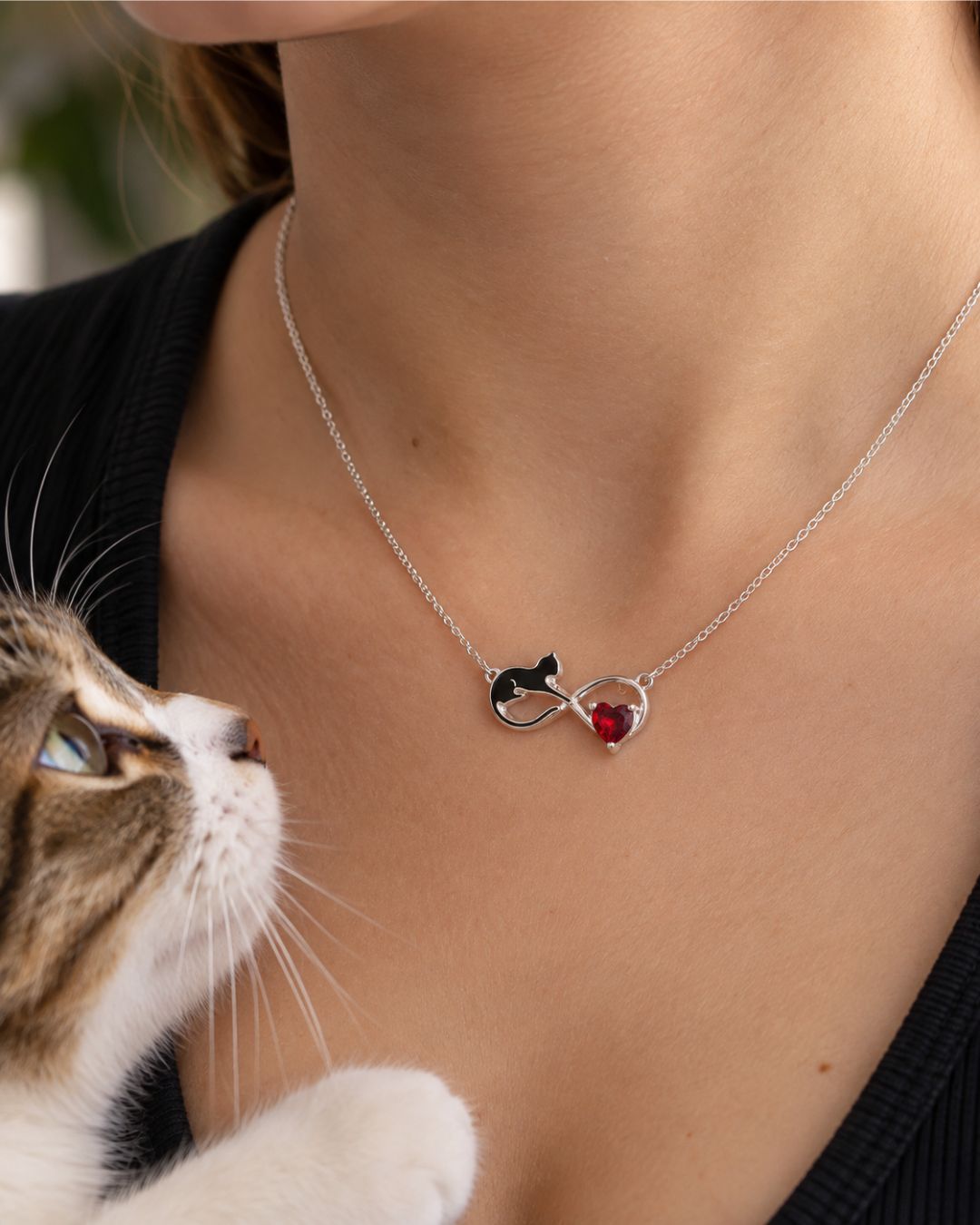 Collar de plata 925 centro infinito con gato esmaltado en negro y circonia corazón color rojo colocado en cuello Collar de plata 925 centro infinito con gato esmaltado en negro y circonia corazón color rojo colocada en cuello