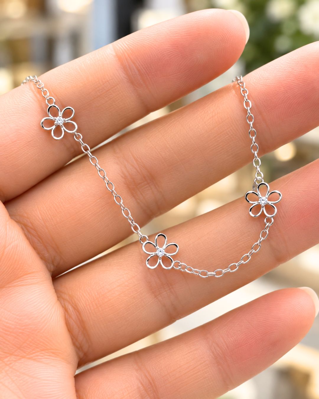 Collar de plata 925 con tres flores caladas con centro de circonia presentado en mano Collar de plata 925 con tres flores caladas con centro de circonia presentado en mano