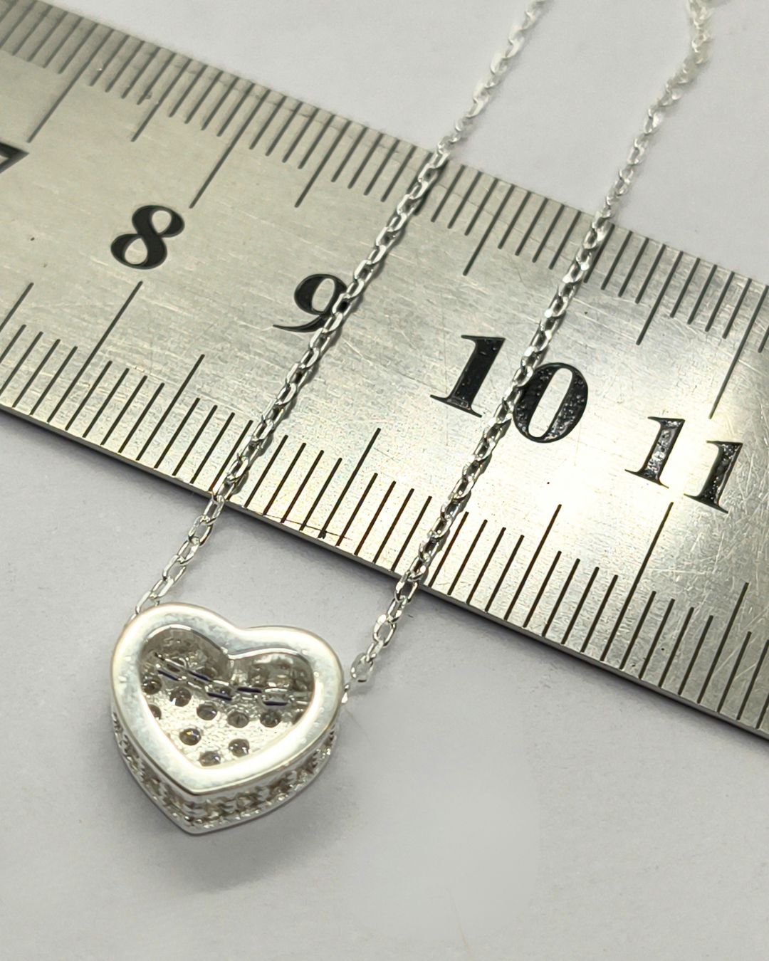 Collar de plata 925 con pasante de corazón pave de circonias en frente y laterales sobre regla para contexto de medida Collar de plata 925 con pasante de corazón pave de circonias en frente y laterales sobre regla para contexto de medida