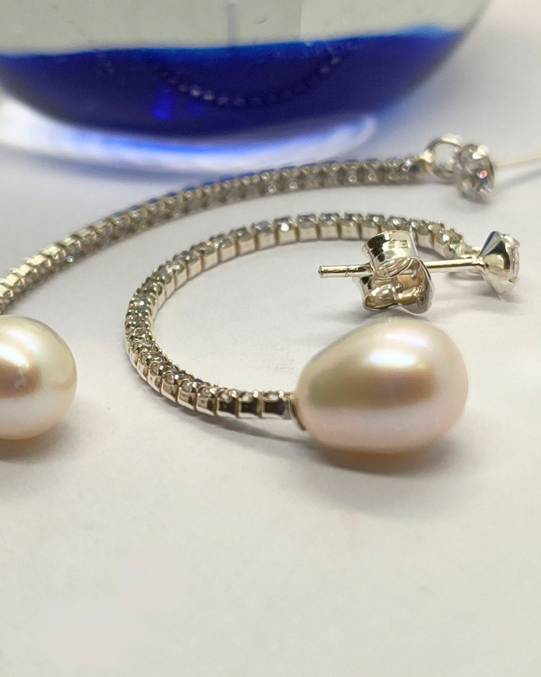 Aros de plata 925 laargos de tira de chatones con circonias y perla de rio en forma de gota vista de plano Aros de plata 925 laargos de tira de chatones con circonias y perla de rio en forma de gota vista de plano