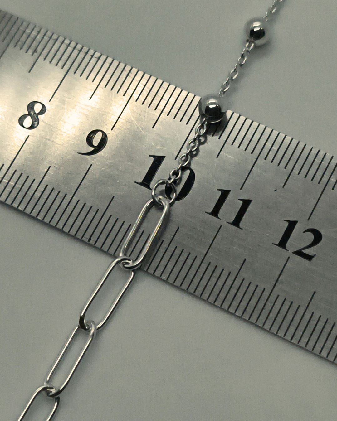 Pulsera de plata 925 centro de eslabones ovales y laterales con bolitas de 4mm con cubic en virola al final del alargue sobre regla para contexto de medida Pulsera de plata 925 centro de eslabones ovales y laterales con bolitas de 4mm con cubic en virola al final del alargue sobre regla para contexto de medida