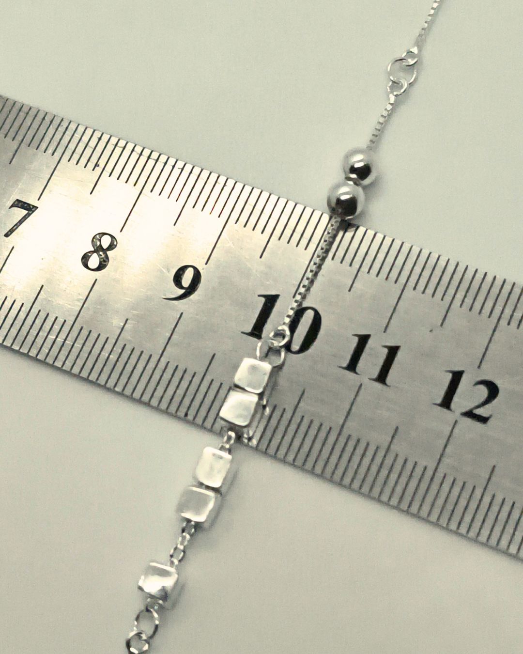 Pulsera de plata 925 con cubos moviles en el centro y bolitas fijas en laterales y con alargue sobre regla para contexto de medida Pulsera de plata 925 con cubos moviles en el centro y bolitas fijas en laterales y con alargue sobre regla para contexto de medida