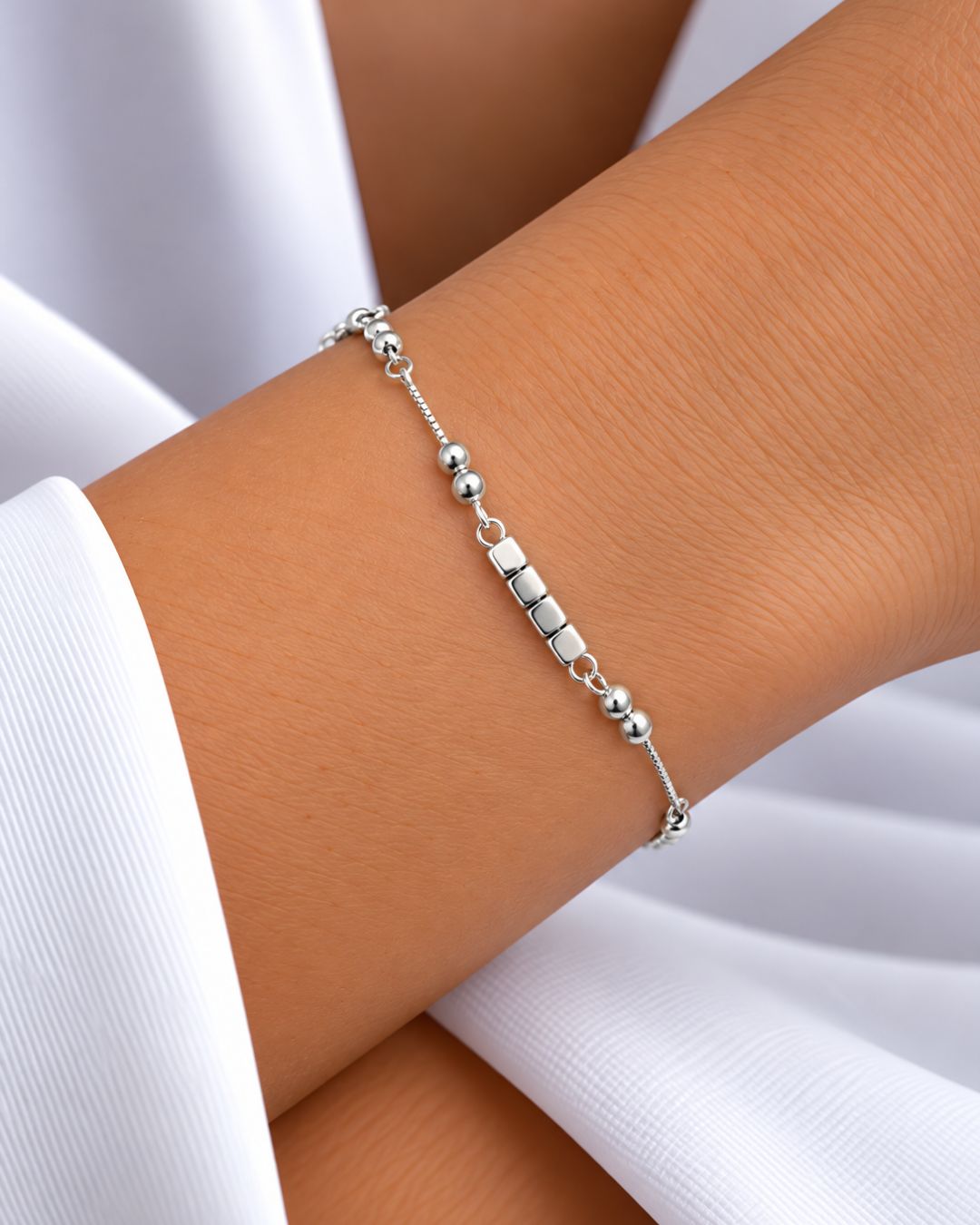 Pulsera de plata 925 con cubos moviles en el centro y bolitas fijas en laterales y con alargue colocada en muñeca Pulsera de plata 925 con cubos moviles en el centro y bolitas fijas en laterales y con alargue colocada en muñeca
